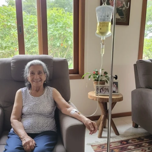 Mujer adulta mayor recibiendo sueroterapia en casa con la Doctora Metabolismo, tratamiento intravenoso para fortalecer el sistema inmune y aumentar vitalidad.